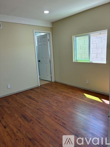 A room with wooden flooring and a fan in it.
