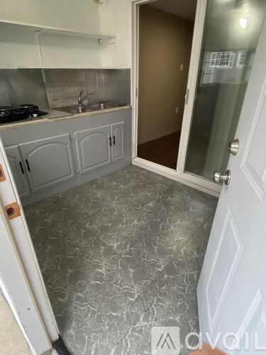 A kitchen with grey cabinets and a sink.