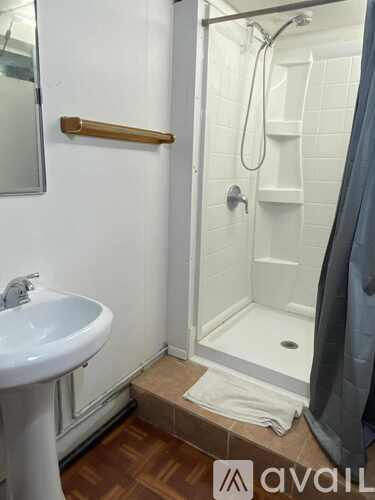 A bathroom with a sink, mirror, and shower.