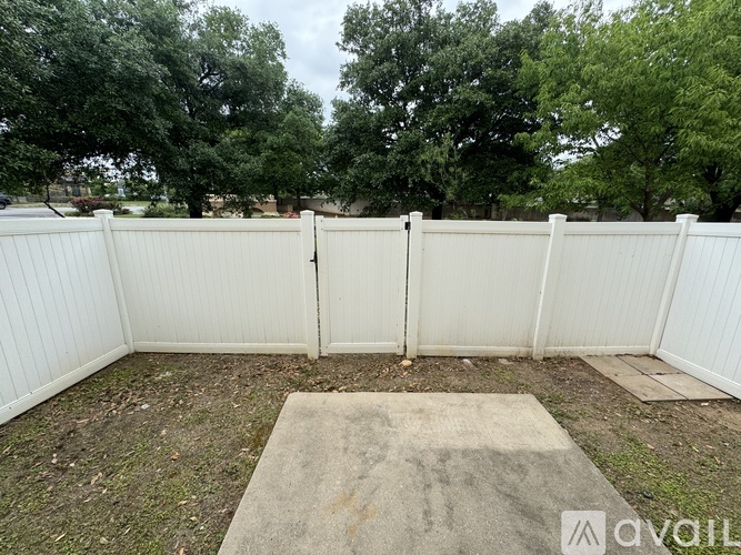 A white fence with a concrete slab in the middle of it.