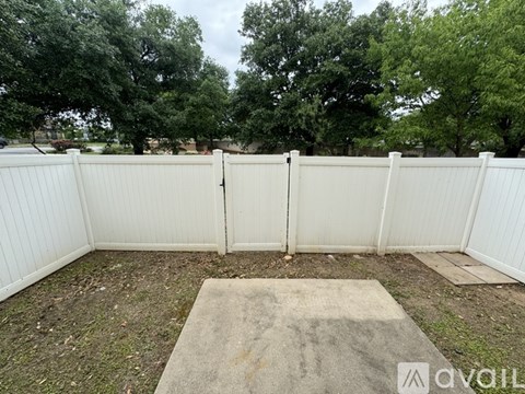 A white fence with a concrete slab in the middle of it.