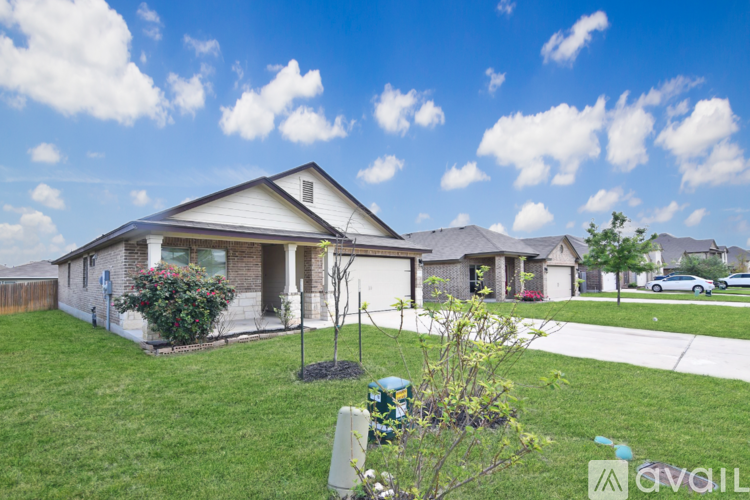 A house with a brown lawn and a fence in the background.