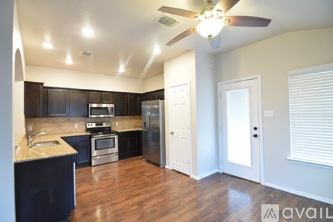 A kitchen with black cabinets and a white stove top oven.
