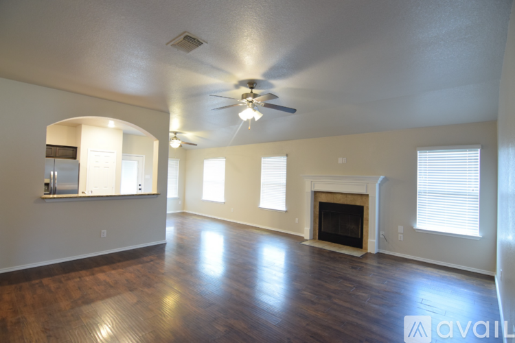 A spacious living room with hardwood floors and a central island.