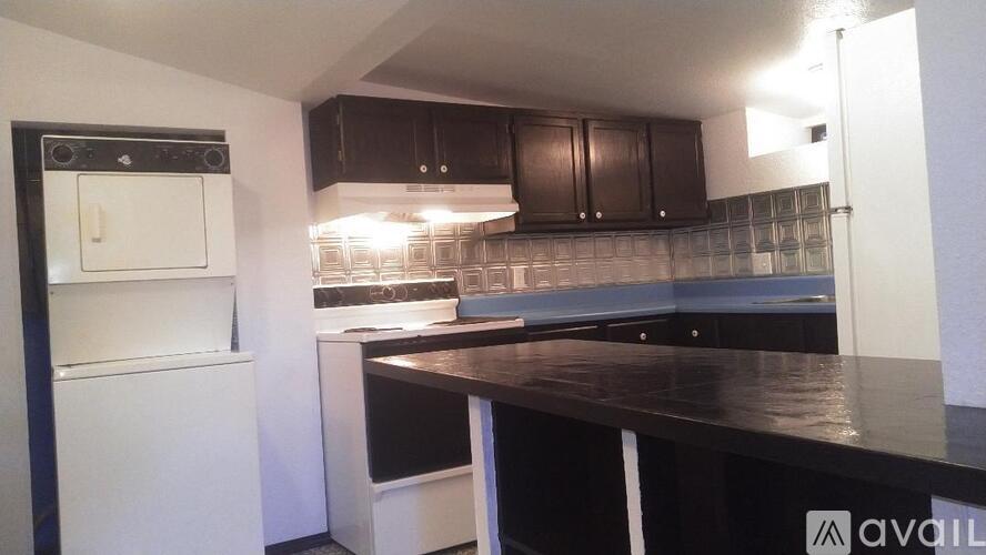 A kitchen with dark brown cabinets and a white fridge.