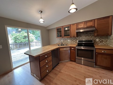 A kitchen with wooden cabinets and a stainless steel oven.