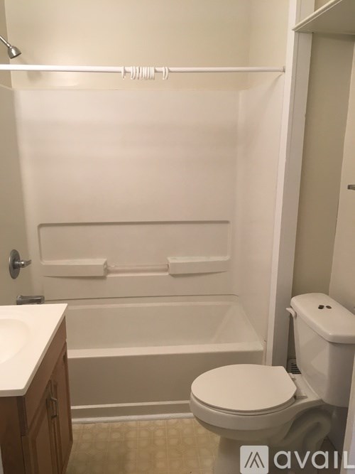 A white toilet sits next to a bathtub in a bathroom.
