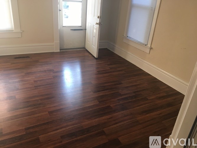 A room with wooden flooring and white walls.