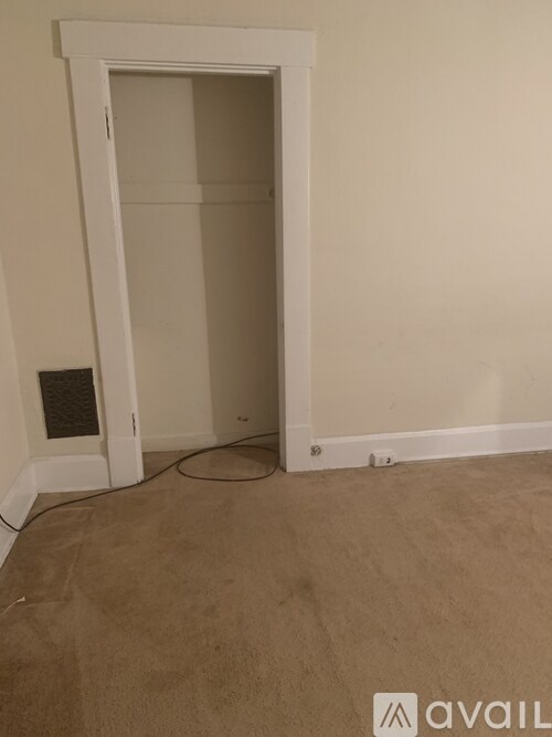 A room with a carpeted floor and a doorway leading to another room.