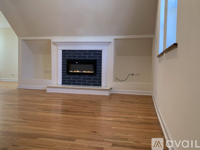 A modern living room with a fireplace and wooden floors.