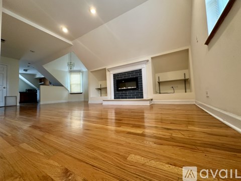 A modern living room with a fireplace and wooden floors.