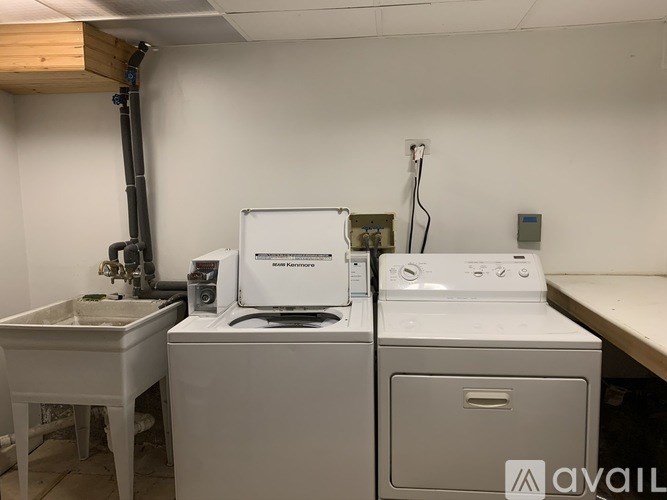 A white washing machine and dryer are on a table in a room.