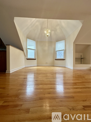 A room with wooden floors and two windows.