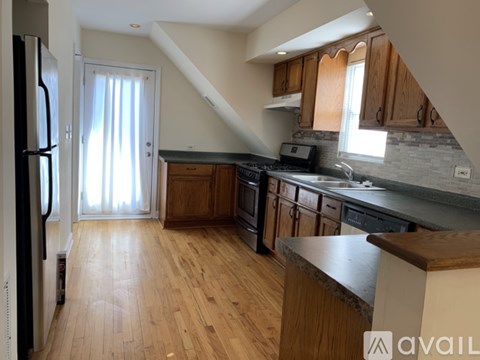 A kitchen with wooden cabinets and a refrigerator.