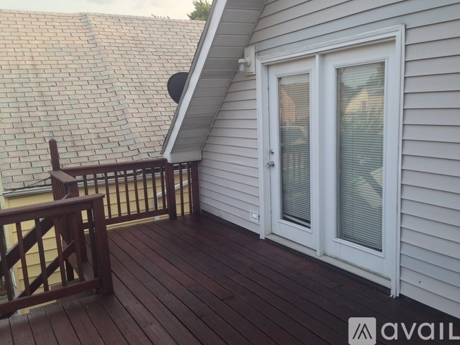 A wooden deck with a white door and a window.