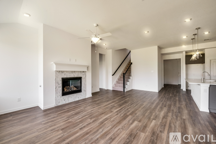 A spacious living room with wood flooring and a fireplace.