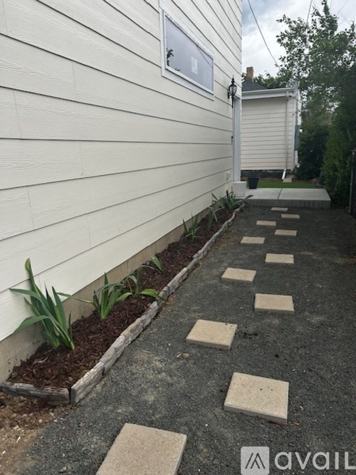 A white house with a small garden in front.
