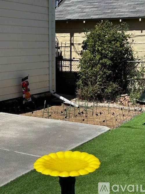 A yellow flower pot is in the foreground of a residential area.