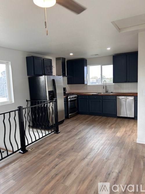 A kitchen with black cabinets and a white dishwasher.