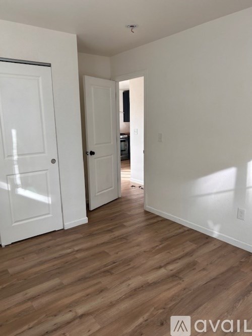 A hallway with wood floors and white walls.
