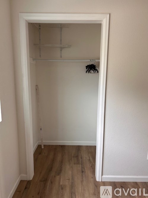 A white closet with a shelf and a hanger.