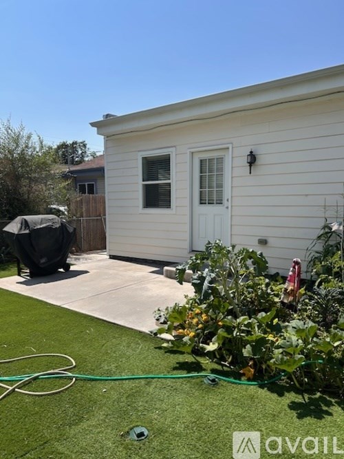 A small white house with a garden in front.