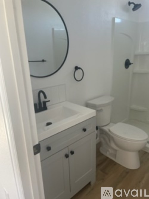 A bathroom with a toilet, sink, and mirror.