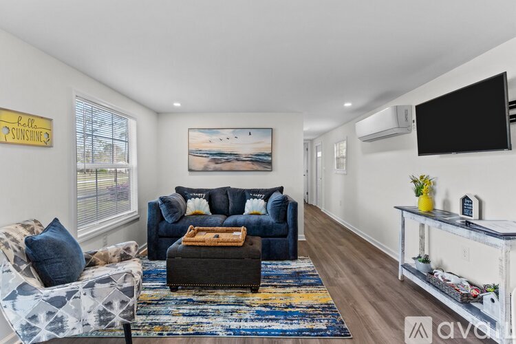 A living room with a blue couch and a rug.