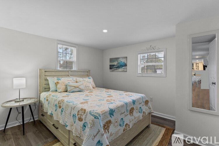 A bedroom with a bed, a small table, and a window.