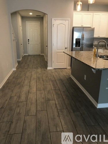 A kitchen with a refrigerator, sink, and cabinets.