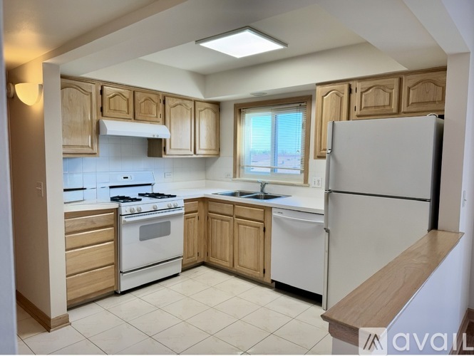 A kitchen with white appliances and wooden cabinets.