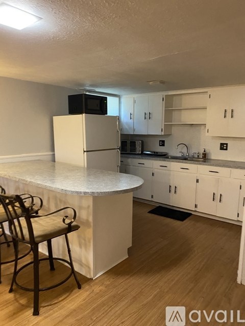 A kitchen with white cabinets and a white island with a countertop.