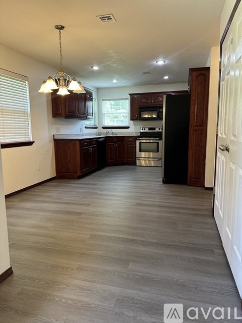 A kitchen with wooden cabinets and a black refrigerator.
