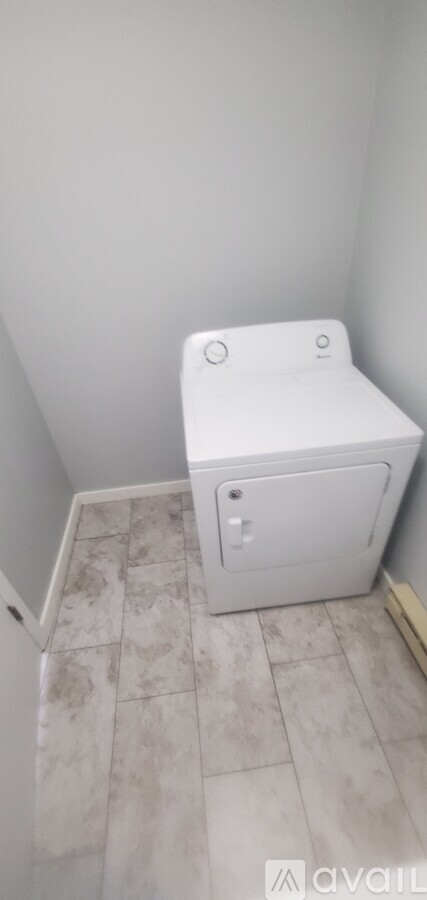 A white toilet in a small bathroom with tiled flooring.