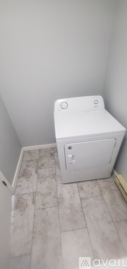 A white toilet in a small bathroom with tiled flooring.