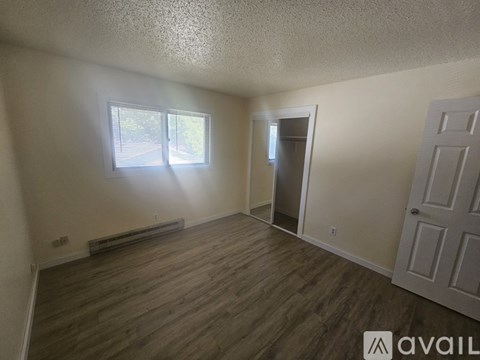 A house with a white exterior and a stone wall is available for rent.