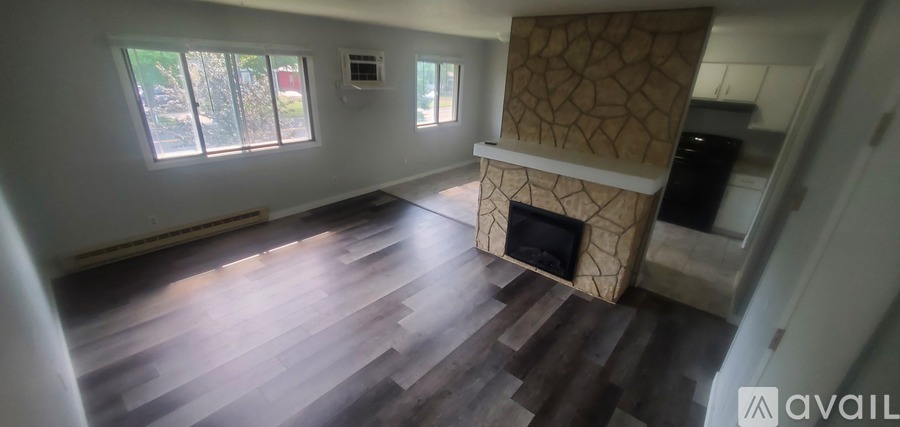 A living room with a fireplace and wooden floors.