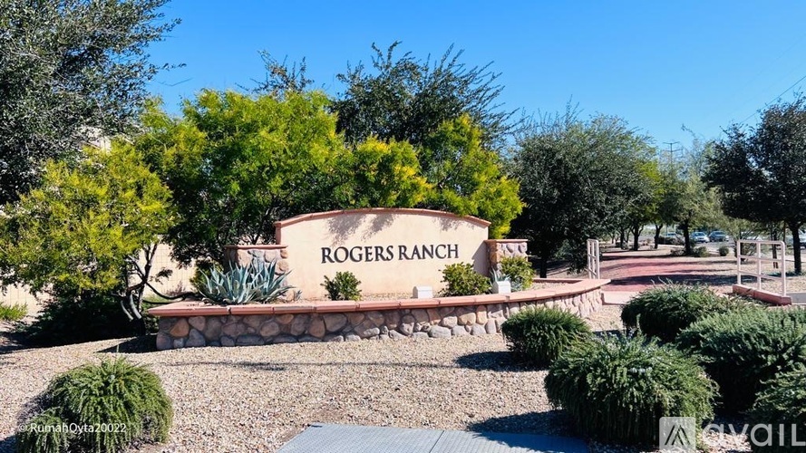 A sign that says Rogers Ranch is surrounded by bushes and trees.