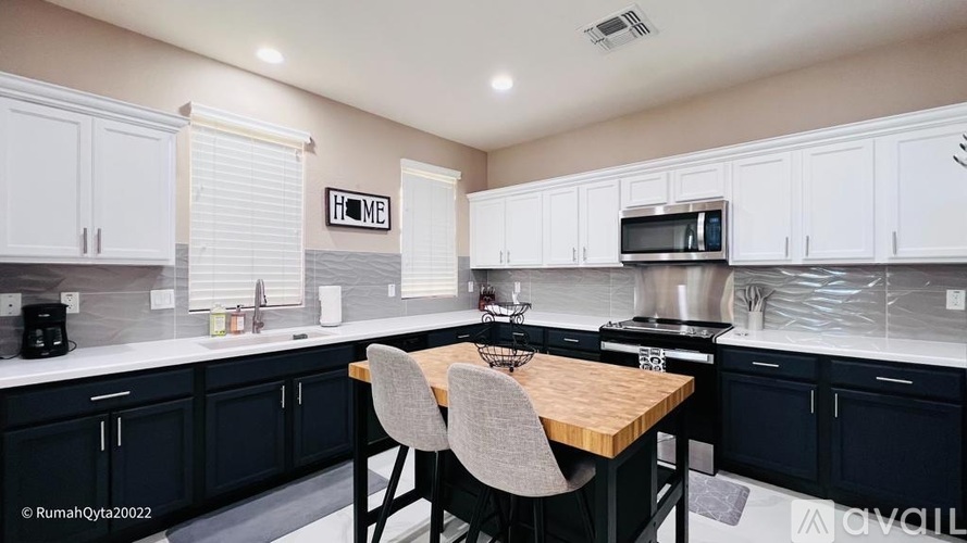 A kitchen with a table and chairs in the middle.