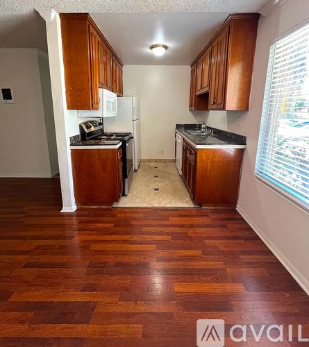 A kitchen with wooden cabinets and a black countertop.
