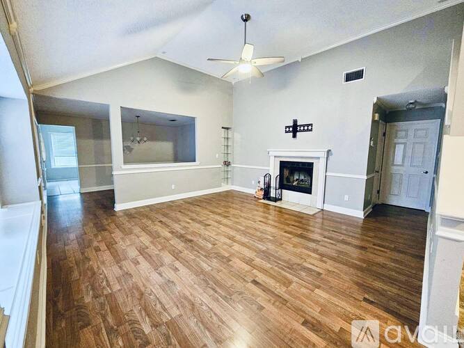 A living room with wood flooring and a fireplace.
