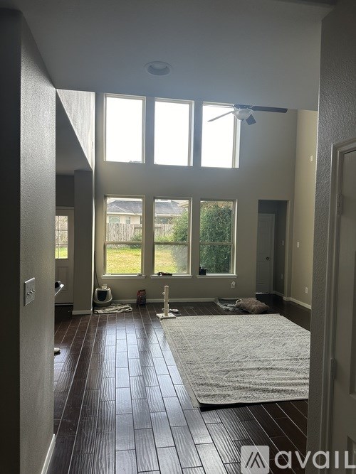 A room with a large window and a ceiling fan.