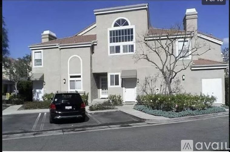 A house with a black car parked in front.
