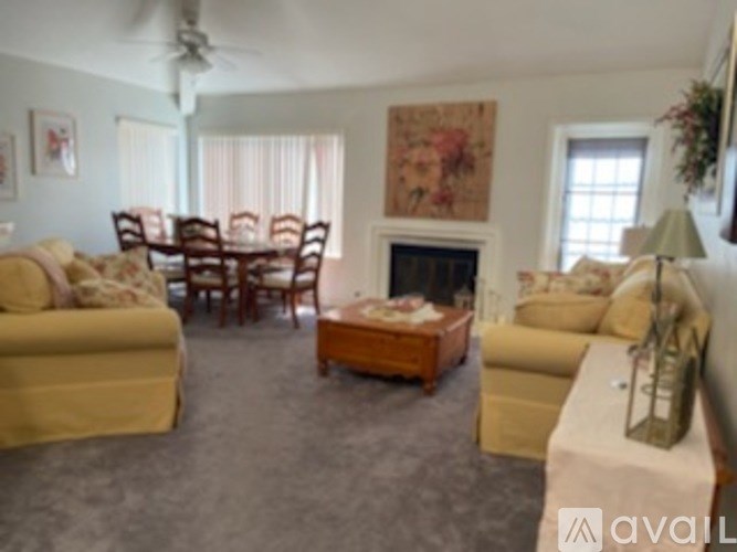 A living room with a fireplace and a painting on the wall.
