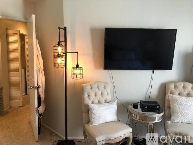 A living room with a chair, a table, a television and a floor lamp.