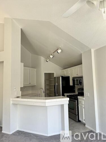 A living room with a brown couch, a grey chair, and a wooden coffee table.