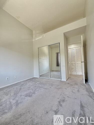 A room with a television and a fireplace with an open door leading to a balcony.