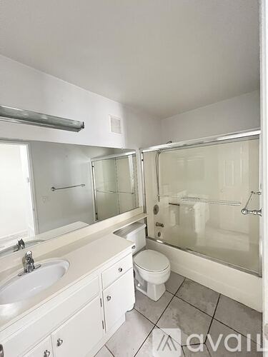 A hallway with a white door and a wall with a window.