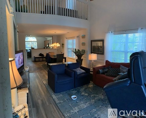 A living room with a blue couch and a television on the left side.