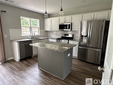 A kitchen with a granite countertop and stainless steel appliances.